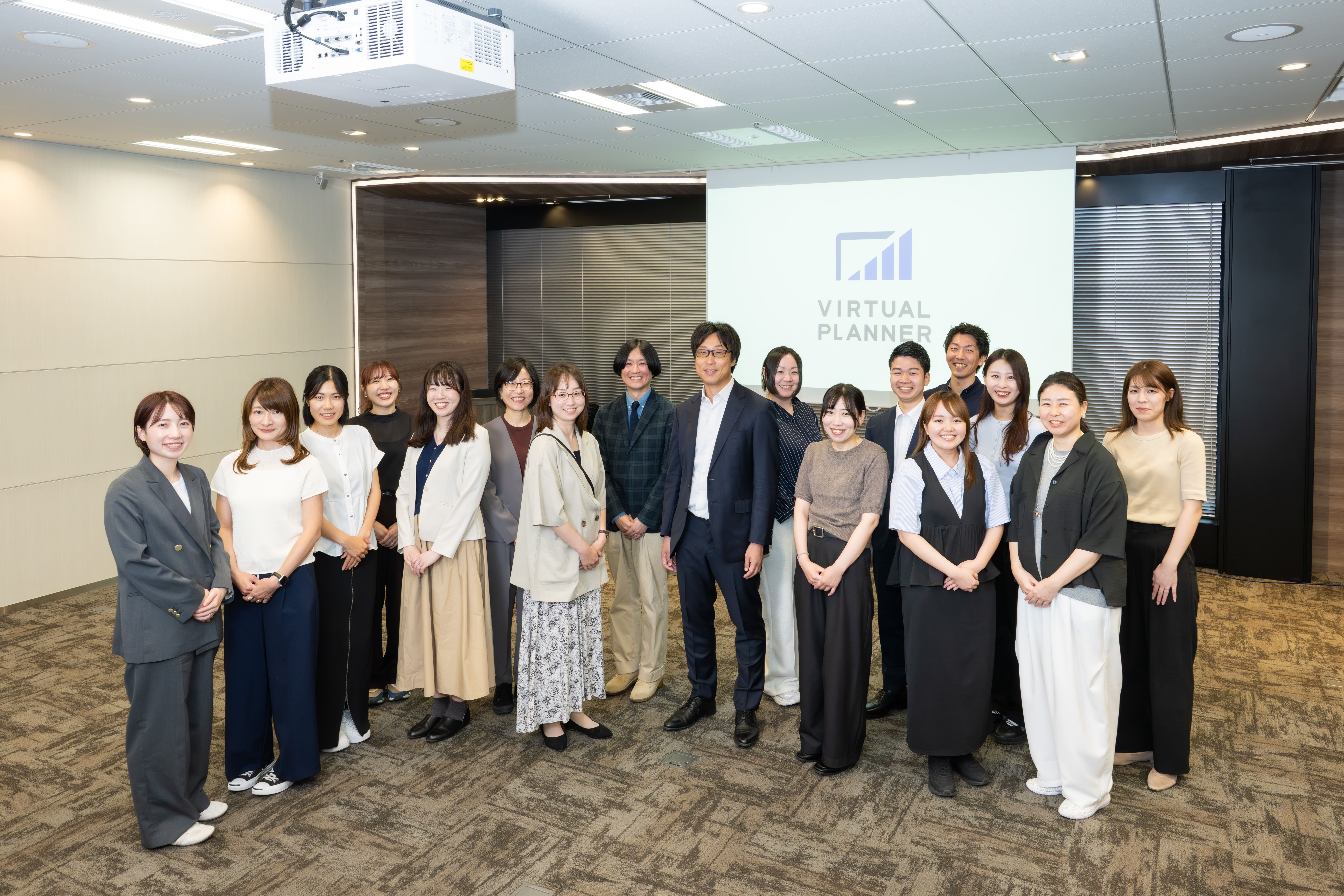 パワーポイント資料作成の社員たちの集合写真。20名以上の確実な内製体制を維持しています
