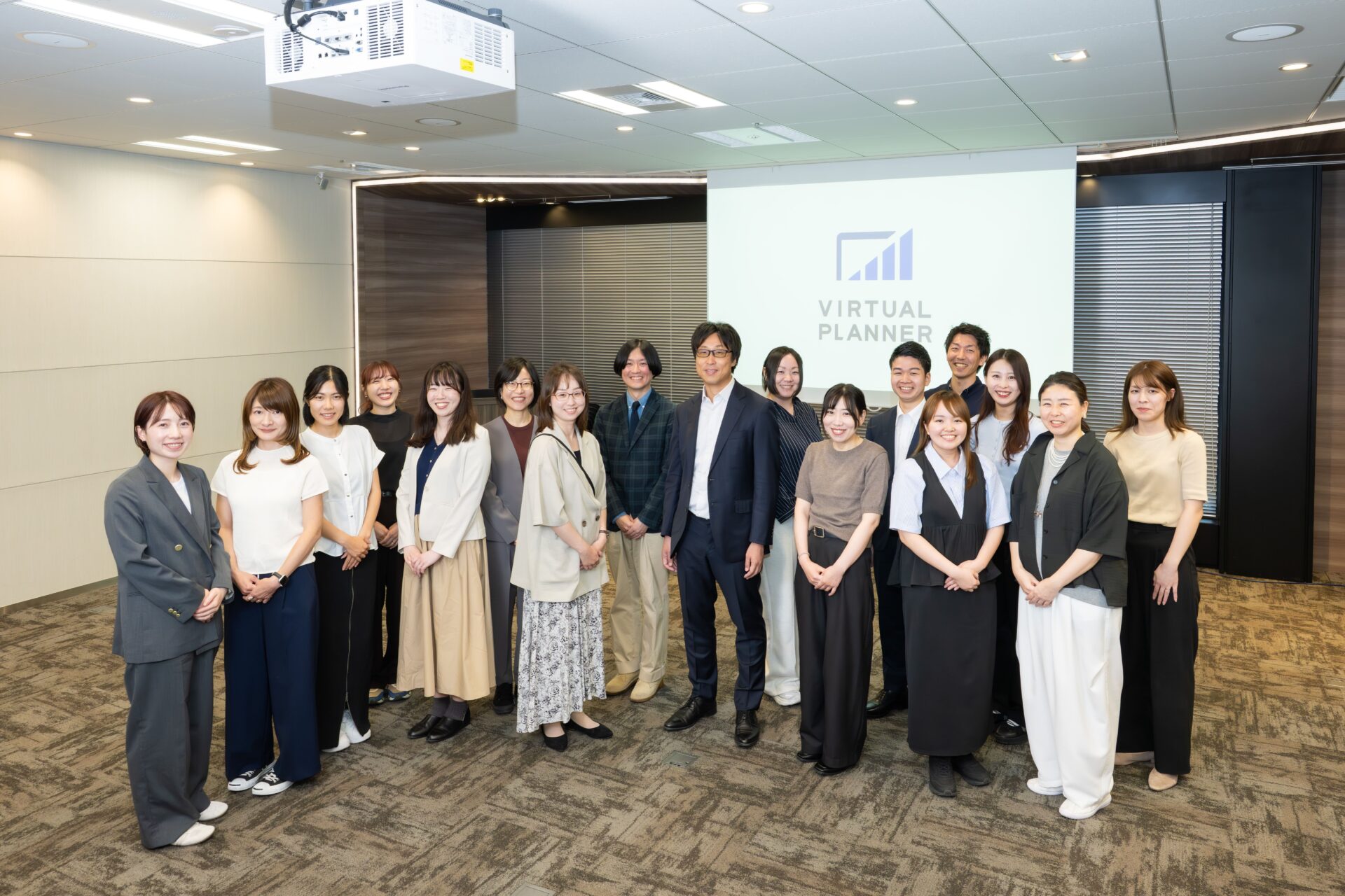 パワーポイント資料作成の社員たちの集合写真。20名以上の確実な内製体制を維持しています